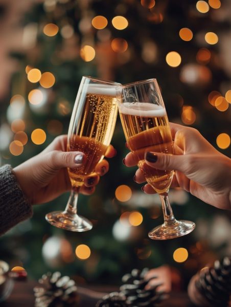 Brinde de Natal com duas taças de espumante, em ambiente festivo com luzes e decoração natalícia.